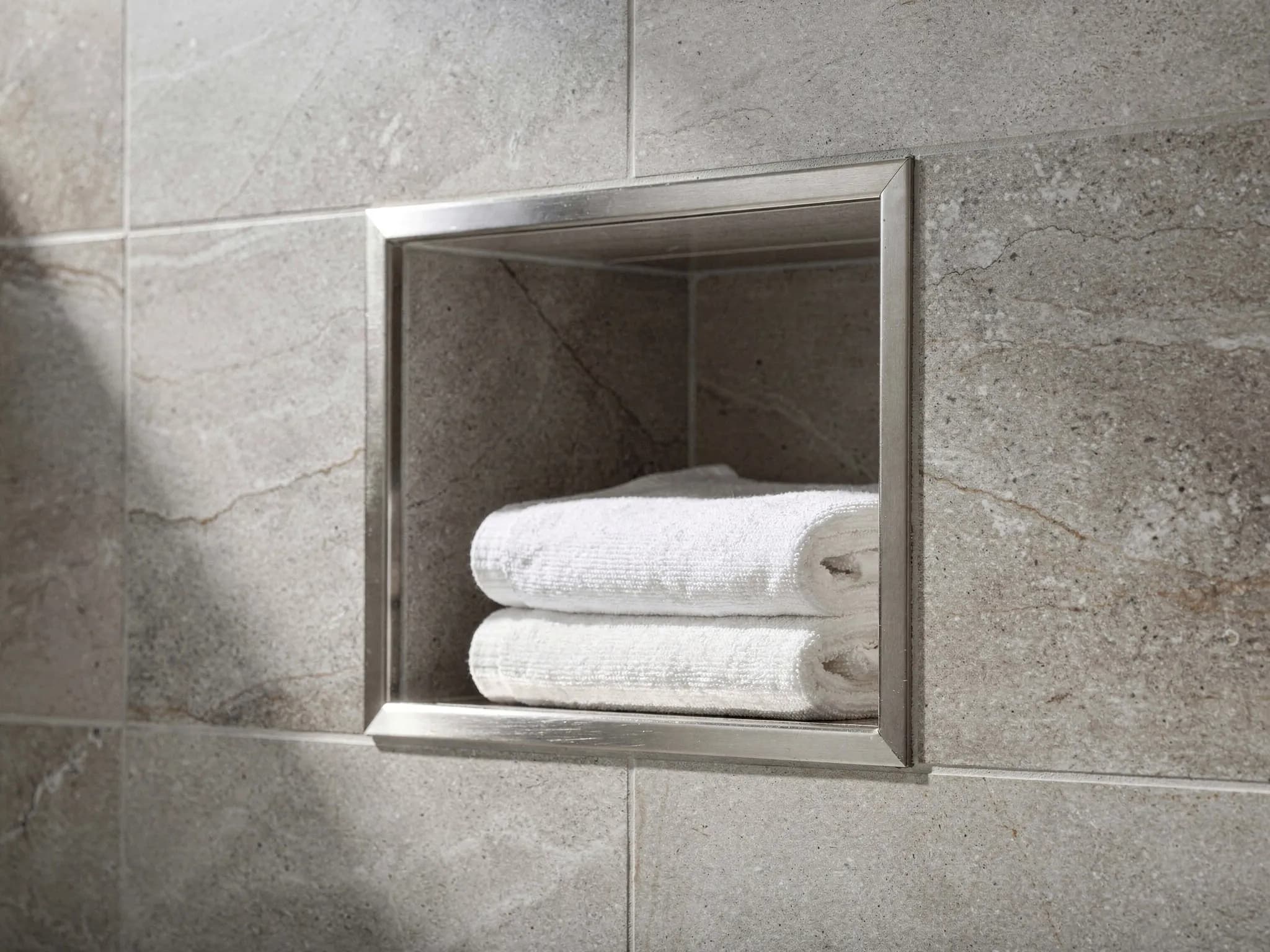 Large-format porcelain shower walls with a built-in niche, waterproofed with a Schluter system underneath.